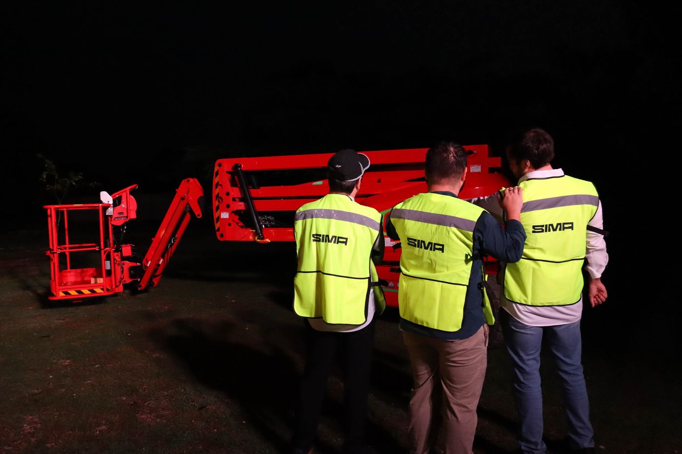 Equipo de SIMA con chalecos de seguridad revisando una plataforma articulada